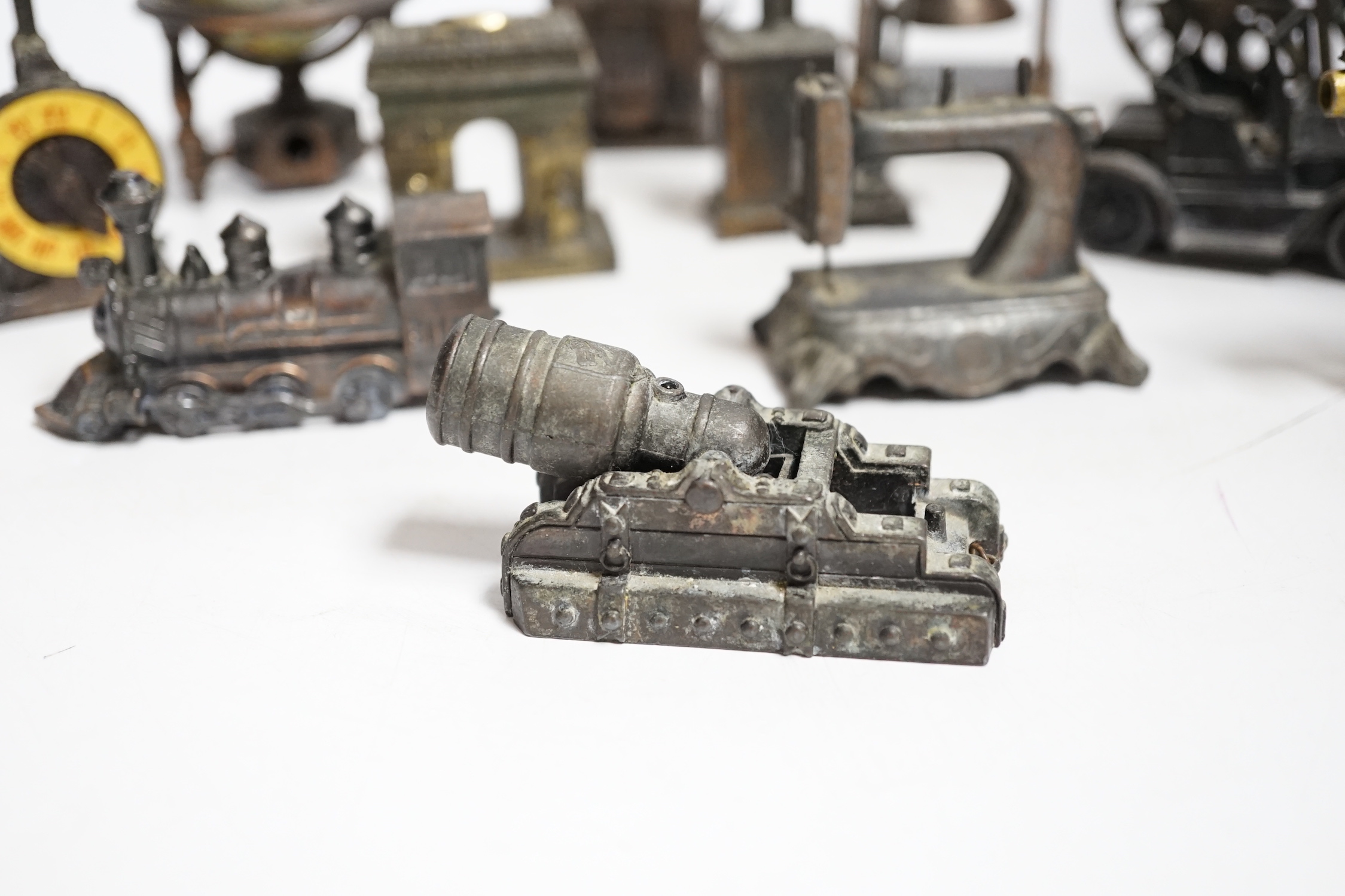 A collection of novelty metal pencil sharpeners and a pair of late Georgian silver plated candlesticks, 20cm